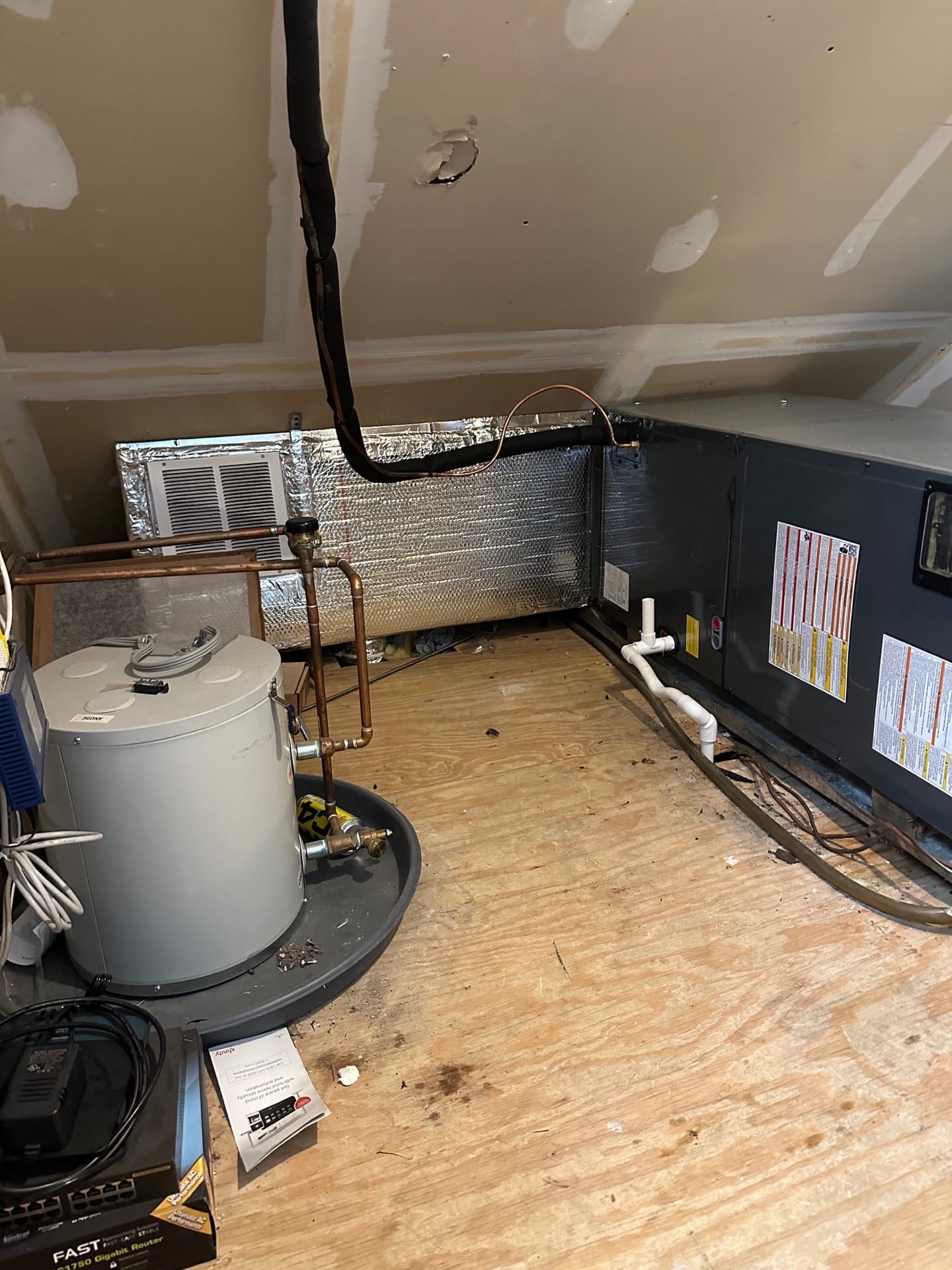 Air handler and evaporator coil installed in a home mechanical closet beside the water heater