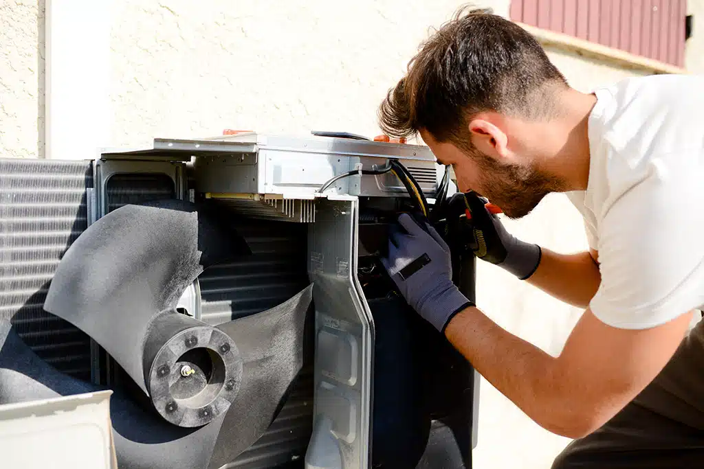 Technician cleaning the coil on a home cooling system
